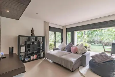 a living room with a couch and a book shelf at 3BR Casa Oasis - Beachfront Home in Laguna & Layan Chom Tawan and Maan Tawan Residences in Phuket Town