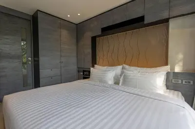 a large bed with white pillows in a bedroom at Luxury Resort City Gate Kamala C33 in Kamala Beach