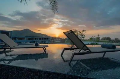 two lounge chairs sitting on top of a swimming pool at Luxury Resort City Gate Kamala C33 in Kamala Beach