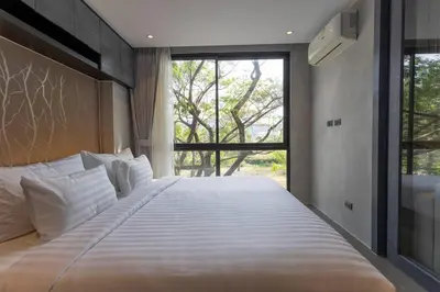 a large bed in a bedroom with a large window at Luxury Resort City Gate Kamala C33 in Kamala Beach
