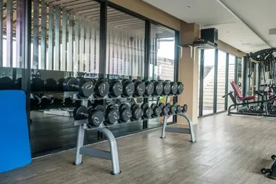 a gym with rows of dumbbells in a room at Aristo Resort Surin Beach M06 in Phuket Town