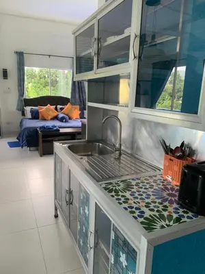 a kitchen with a sink and a living room at Villa du Bonheur Mer et Nature Rawai beach in Phuket Town