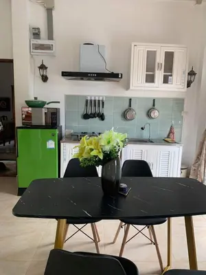 a kitchen with a table with a vase of flowers on it at Villa du Bonheur Mer et Nature Rawai beach in Phuket Town