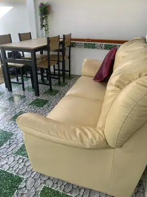 a couch sitting in a living room with a table at Villa du Bonheur Mer et Nature Rawai beach in Phuket Town