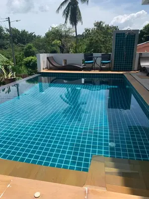 a swimming pool with blue tiles in a resort at Villa du Bonheur Mer et Nature Rawai beach in Phuket Town
