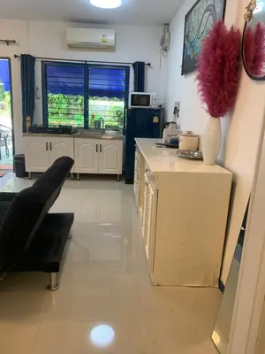 a kitchen with white cabinets and a sink and a table at Villa du Bonheur Mer et Nature Rawai beach in Phuket Town