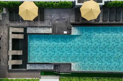 an overhead view of a swimming pool with two umbrellas at Chateau Du Village Patong in Patong Beach