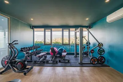 a gym with blue walls and a large window at Great value! Convenient studio near Kamala beach in Kamala Beach