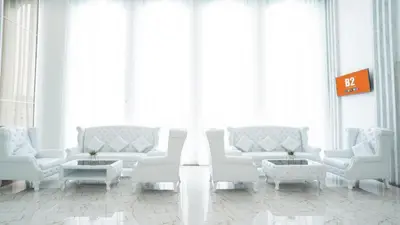a living room with white furniture and large windows at B2 Phuket Premier Hotel in Ban Ket Ho