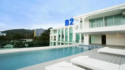 a building with a swimming pool in front of a building at B2 Phuket Premier Hotel in Ban Ket Ho