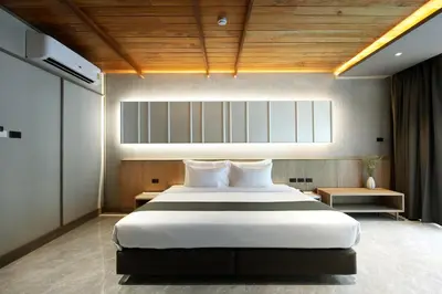 a bedroom with a large white bed and wooden ceilings at Luminous Resort & Spa by Areca in Phuket Town