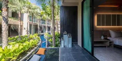an outdoor patio with a pool and palm trees at Luminous Resort & Spa by Areca in Phuket Town