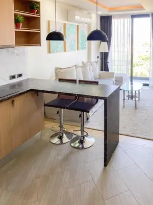 a kitchen with a table with chairs and a couch at Appartements avec piscine in Rawai Beach