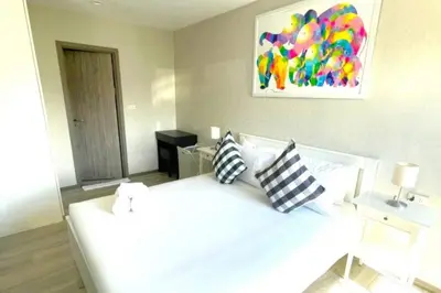 a bedroom with a white bed with pillows and a painting at B5 НОВАЯ вид БАССЕЙН ВАТСАП669З582I976 in Phuket Town