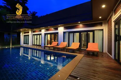 a house with a swimming pool with orange chairs at Viangviman Luxury Resort, Krabi in Ao Nang Beach