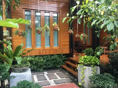 a wooden house with plants in front of it at Viangviman Luxury Resort, Krabi in Ao Nang Beach