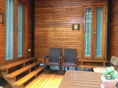 two chairs on the porch of a wooden house at Viangviman Luxury Resort, Krabi in Ao Nang Beach