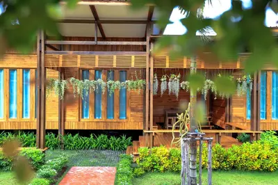 a wooden house with blue windows in a yard at Viangviman Luxury Resort, Krabi in Ao Nang Beach