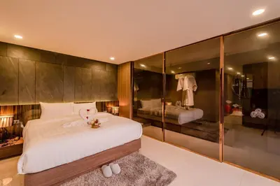 a bedroom with a large bed and a bathroom at Duplex Pool Access 2brs Patong in Patong Beach