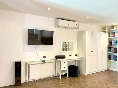 a room with a desk and a tv on a wall at Duplex Pool Access 2brs Patong in Patong Beach