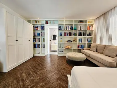 a living room with a couch and book shelves at Duplex Pool Access 2brs Patong in Patong Beach