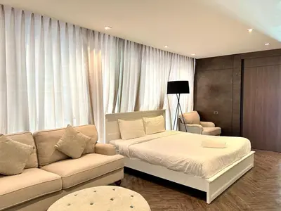 a bedroom with a bed and a couch at Duplex Pool Access 2brs Patong in Patong Beach