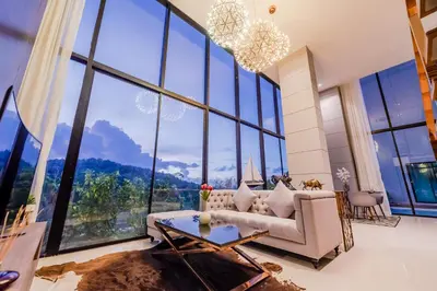 a living room with large windows and a chandelier at Duplex Pool Access 2brs Patong in Patong Beach
