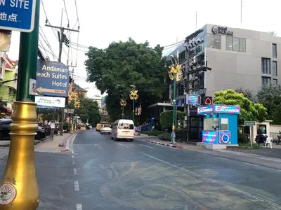 a city street with a white van driving down the street at Cozy Patong studio apartment in Patong Beach