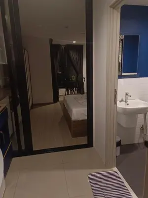 a bathroom with a mirror and a bed and a sink at The base central phuket in Phuket Town