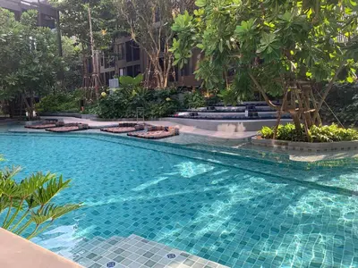 a swimming pool in the middle of a building with trees at The base central phuket in Phuket Town