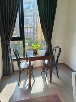 a table and chairs in a room with a window at The base central phuket in Phuket Town