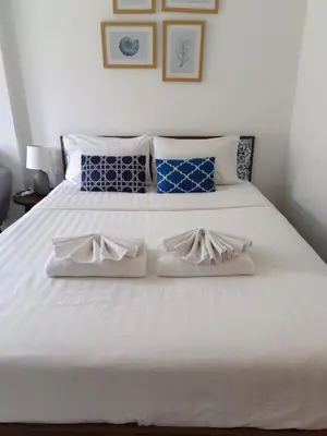 a white bed with two white shoes on it at The base central phuket in Phuket Town