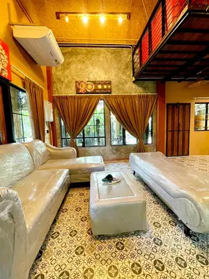 a large living room with a couch and a table at Baibon1 Boutique House Thalang Phuket in Ban Na Nai