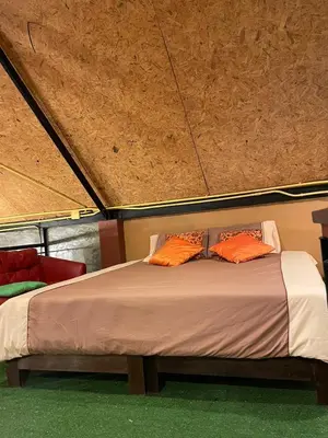 a bed in a tent with two orange pillows on it at Baibon1 Boutique House Thalang Phuket in Ban Na Nai