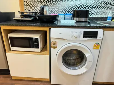 a washing machine and a microwave in a kitchen at Naithon Beachfront Condotel in Nai Thon Beach