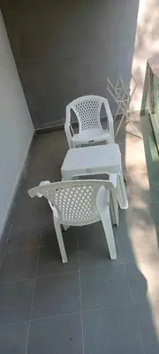 a white chair and a table in a room at Naithon Beachfront Condotel in Nai Thon Beach
