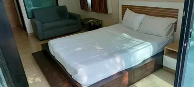 a bedroom with a large bed and a chair at Naithon Beachfront Condotel in Nai Thon Beach