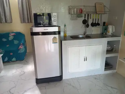 a kitchen with a microwave on top of a refrigerator at Kathu Waterfall Bungalow Holyday home in Ban Huai Luk (1)