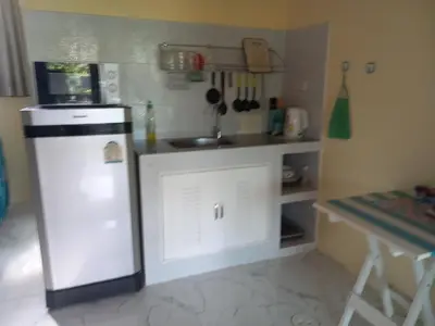 a small kitchen with a refrigerator and a sink at Kathu Waterfall Bungalow Holyday home in Ban Huai Luk (1)