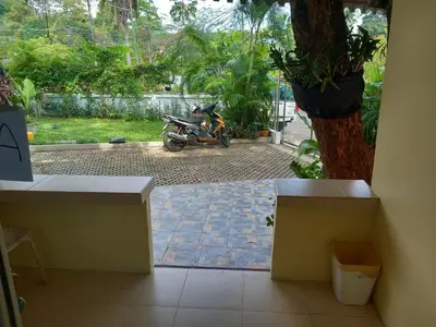 a motorcycle parked in a courtyard with a tree at Kathu Waterfall Bungalow Holyday home in Ban Huai Luk (1)