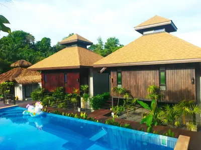 a resort with a swimming pool and two huts at Baan Koh Kwang Pool Villa Krabi in Krabi town