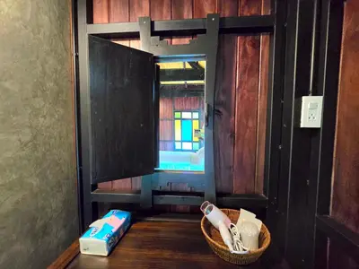 a bathroom with a basket of brushes and a window at Baan Koh Kwang Pool Villa Krabi in Krabi town