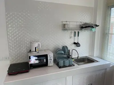 a kitchen counter with a microwave and a sink at Kata Hillside Hideaway in Kata Beach