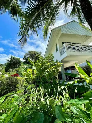 a house with a balcony on the side of it at Kata Hillside Hideaway in Kata Beach