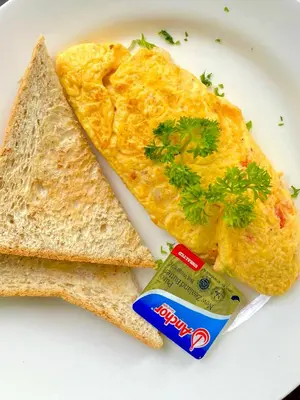 a white plate with an omelet and two slices of toast at Kata Hillside Hideaway in Kata Beach