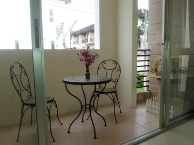 a table with two chairs and a vase with flowers on it at The Green House in Kata Beach