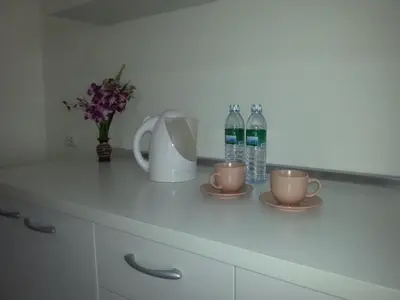 a kitchen counter with two cups and two bottles of water at The Green House in Kata Beach