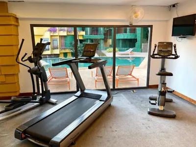 a gym with two exercise bikes and a swimming pool at Kata Sea View Sanctuary in Kata Beach