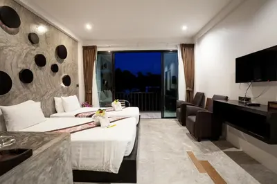 a hotel room with two beds and a flat screen tv at Aonang Viva Resort - SHA Plus in Ao Nang Beach