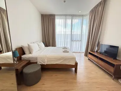 a hotel room with a bed and a television at 2 Bedroom Beachfront Apartment With Sea Views in Mai Khao Beach